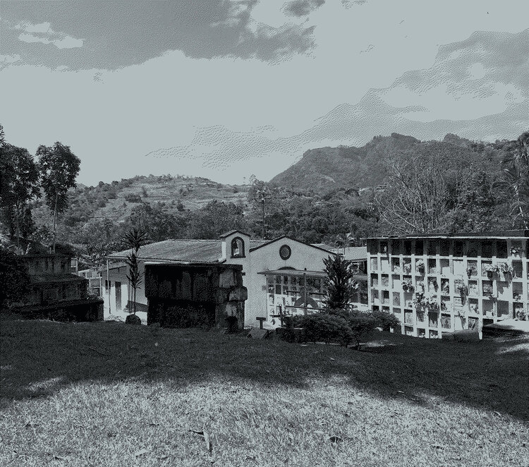 Landscape with mountains, sky and a cemetery in the foreground.