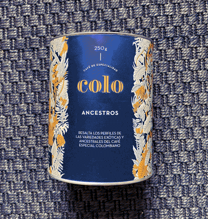 Cylindrical blue coffee packaging on a blue carpeted background that says 'Café de especialidad COLO Ancestros', there are illustrations of plants on the packaging.